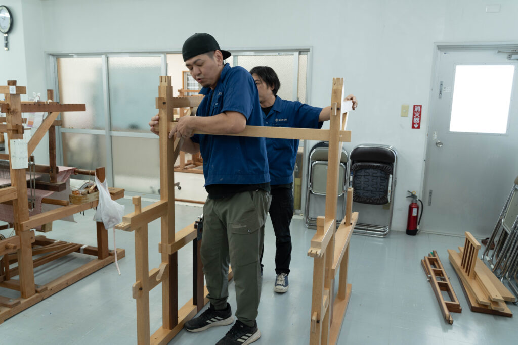 宮良木工所の職人が改良型織り機のフレームを組み立てる様子